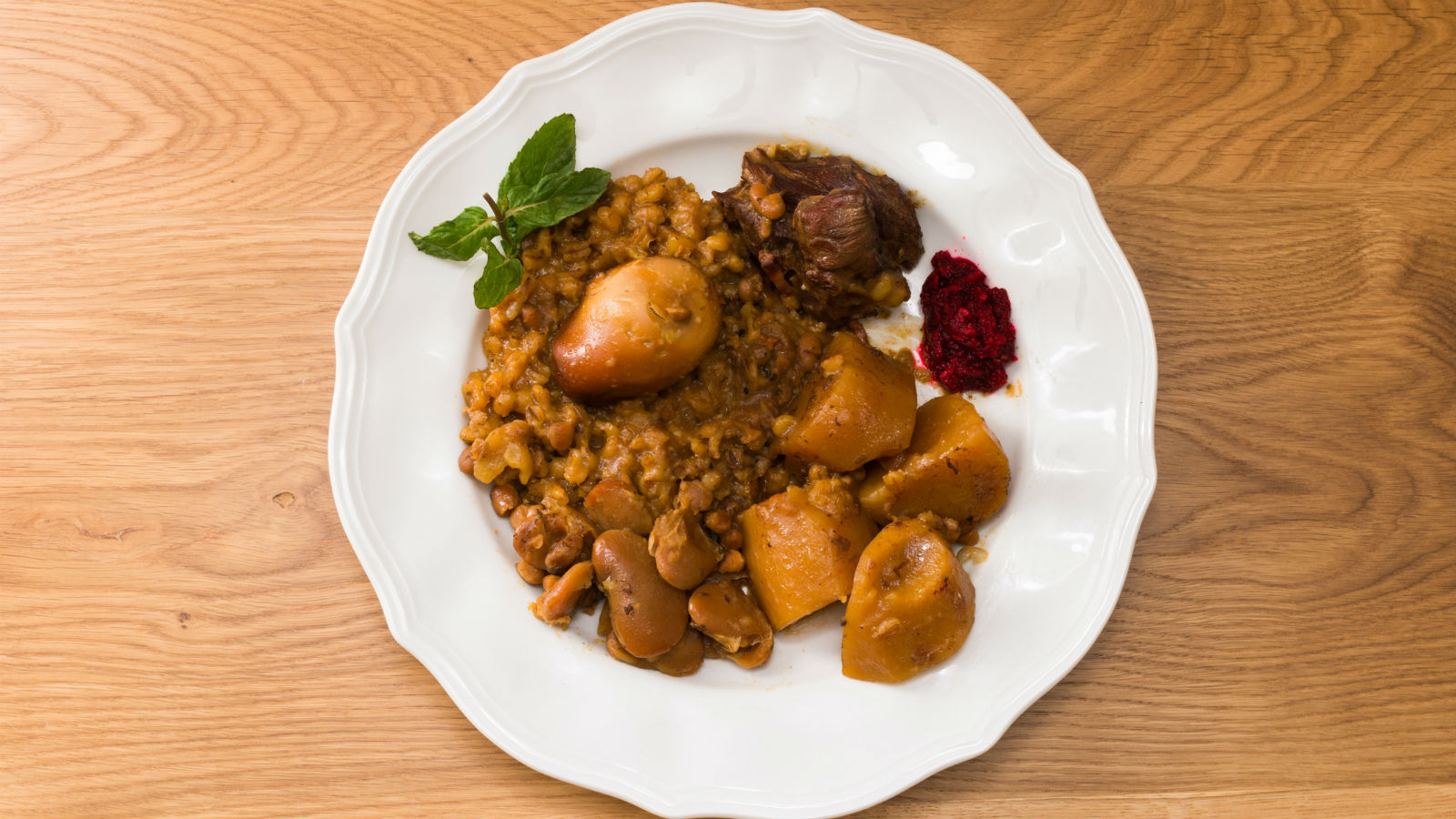 Hot plate for the Sabbath, a pot of spicy meat cooked with potatoes,  barleys, wheat and eggs. Pot of cholent Hamin in hebrew, challah-special  bread in Jewish cuisine. Traditional food Jewish Shabbat