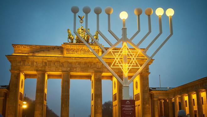 huge outdoor menorah in front of an arch