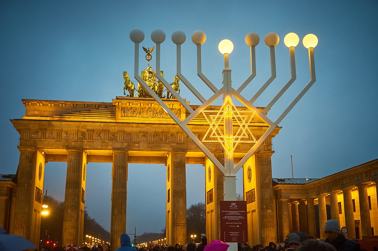 huge outdoor menorah in front of an arch