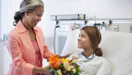 Mother bringing daughter flowers in hospital