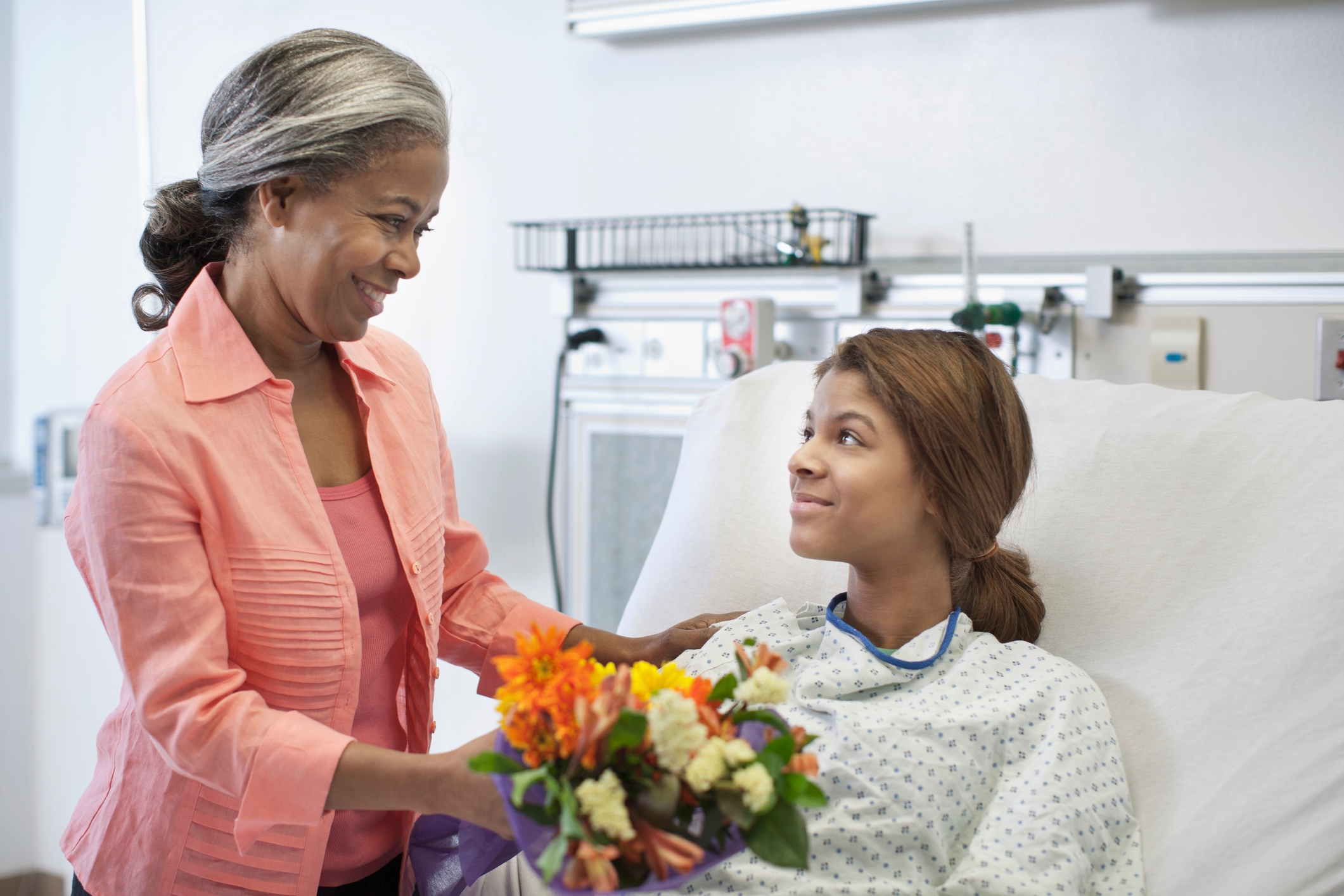 Mother bringing daughter flowers in hospital