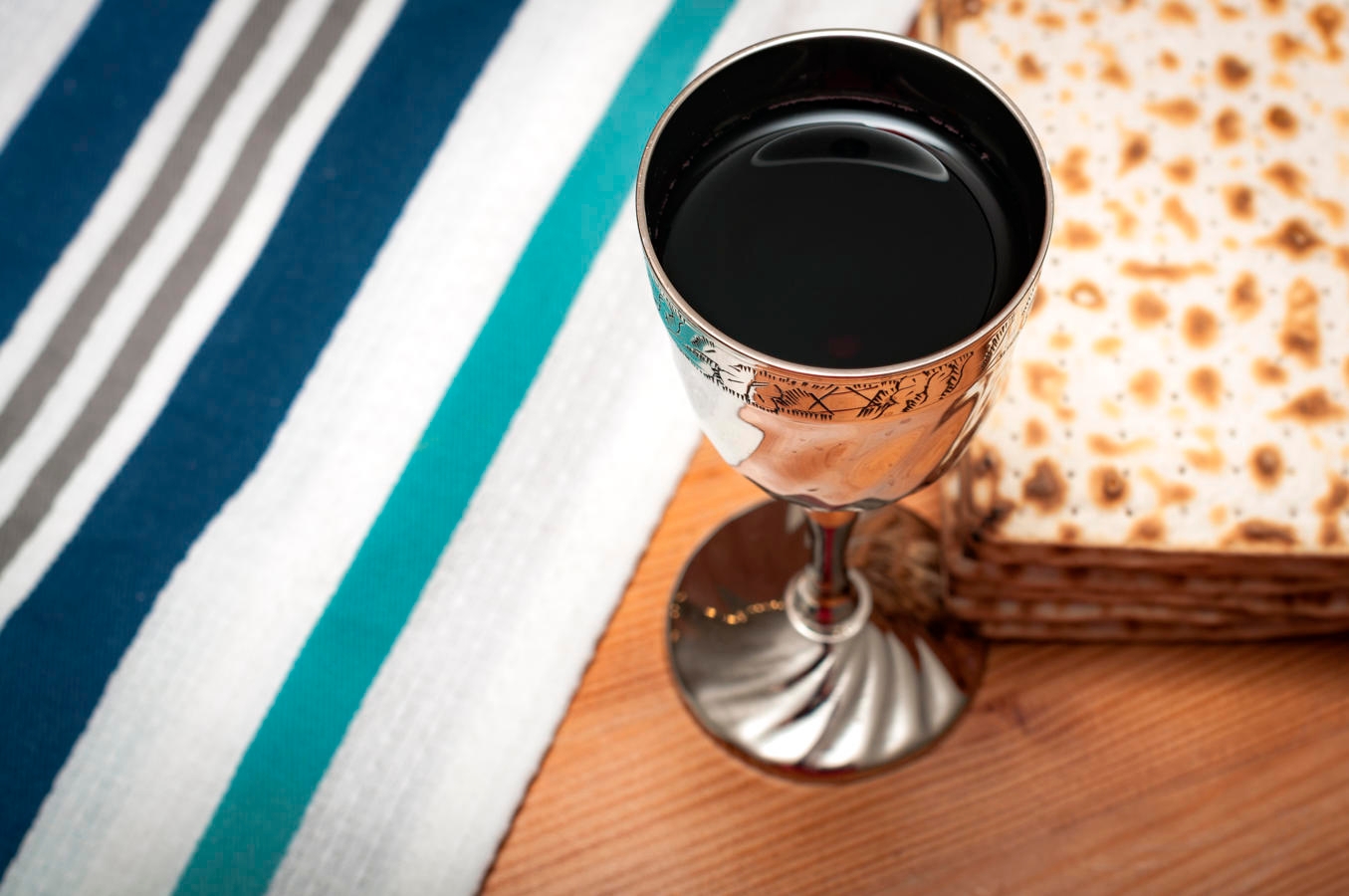 A Kiddush cup filled with wine next to matzah, the unleavened bread that is traditionally eaten during the Jewish holiday of Passover