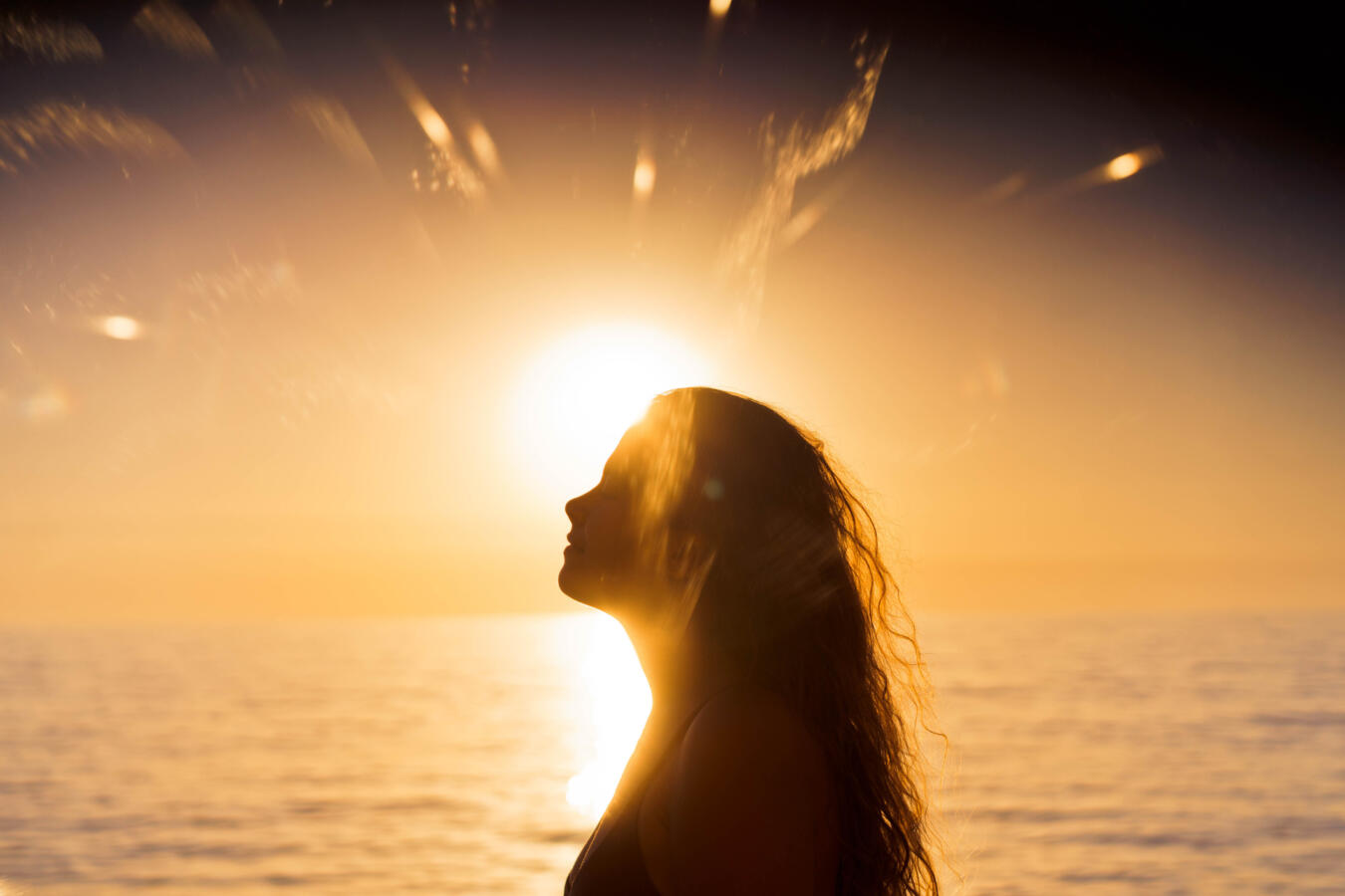 Woman silhouetted at sunset.