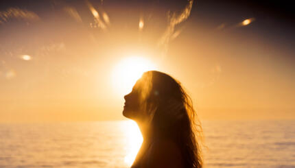 Woman silhouetted at sunset.