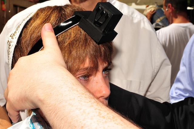 A boy celebrating his bar mitzvah puts on tefillin, Jerusalem, 2008. (iStock)