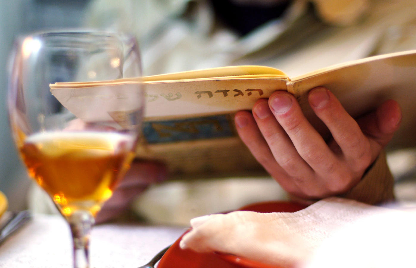 Man reads in the Haggadah book during Passover Seder dinner.