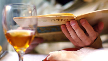 Man reads in the Haggadah book during Passover Seder dinner.