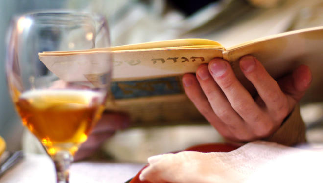 Man reads in the Haggadah book during Passover Seder dinner.