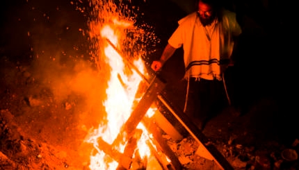 jewish man by bonfire in mt meron, israe