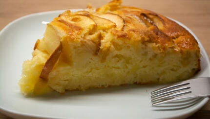 A piece of apple pie on a white plate with a fork. Photo of cake apple kugel recipe easy