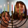 photo of sisters staring at a lit hanukkah menorah