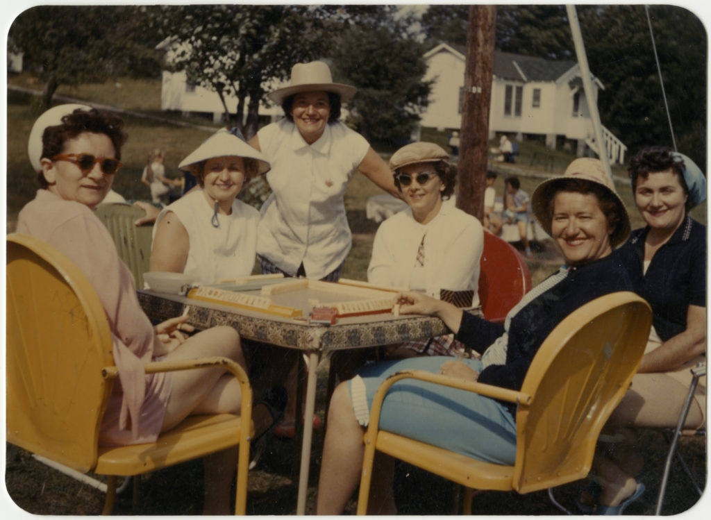 Women playing mah jongg outdoors. 