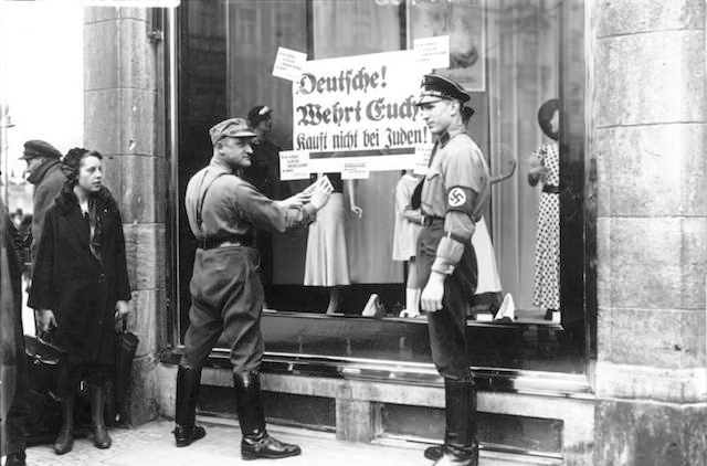 Nazis affix a sign to Jewish store urging shoppers not to patronize it, 1933. (German Federal Archives/Wikimedia Commons)