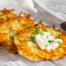 close up photo of latkes with sour cream and chives