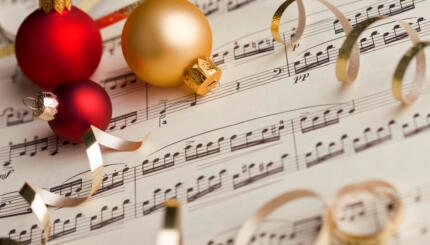 christmas ornaments lying on top of sheet music