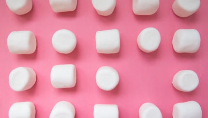 white marshmallows on a pink background.