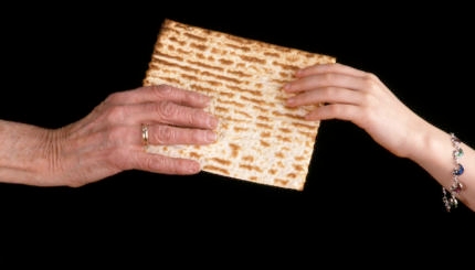 Handing a matzo from an old hand to a young hand.