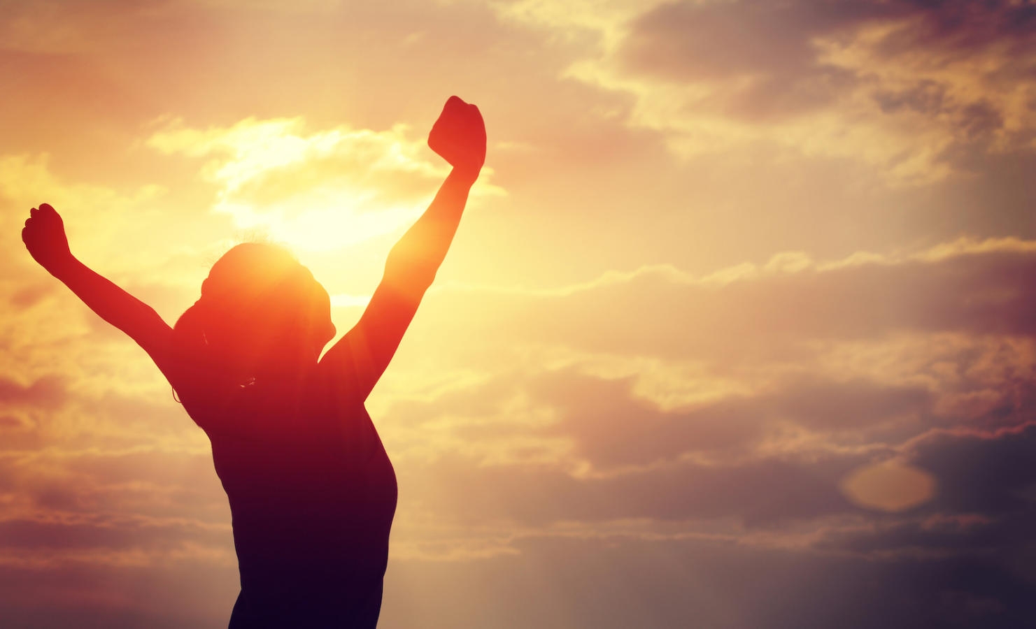 strong confident woman open arms to sunrise at sea