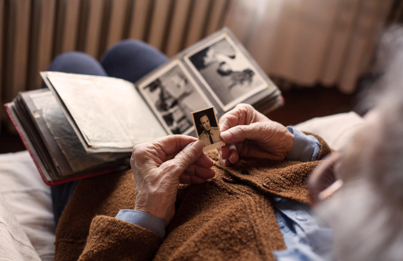 Senior adult woman looking at an old photo of her husband.