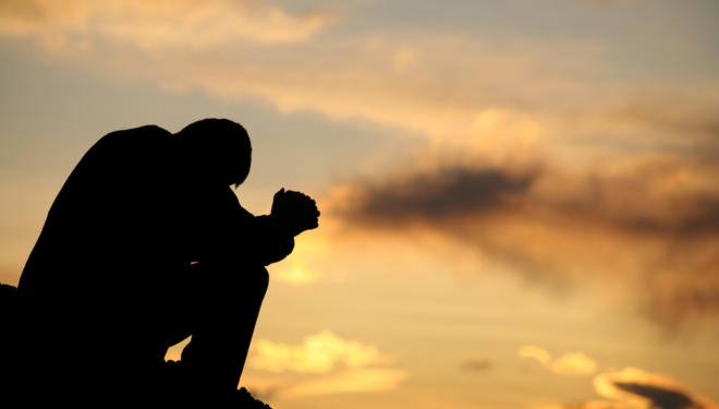 Silhouette of Unrecognizable Man Praying Outside