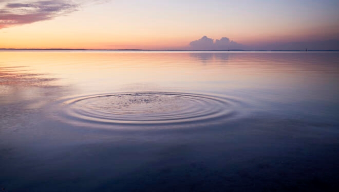 Rings in water of the sea and reflection of the sky during sunset