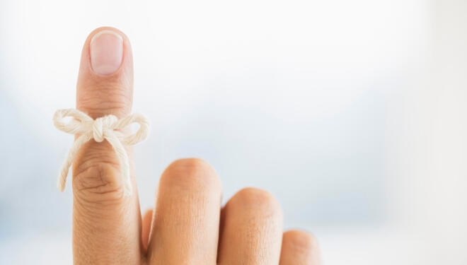 Hand with reminder bow on finger