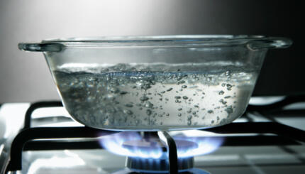 Glass saucepan on the gas stove close-up