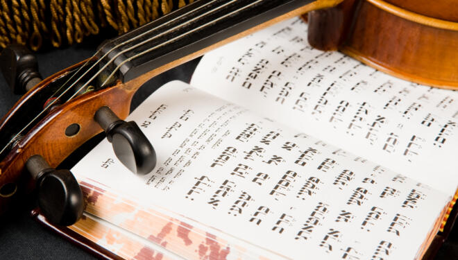 Photo of an open book of psalms and a violin.