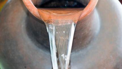 Close up Pour water out of terracotta pots.