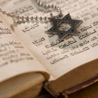 star of david resting on an open torah scroll