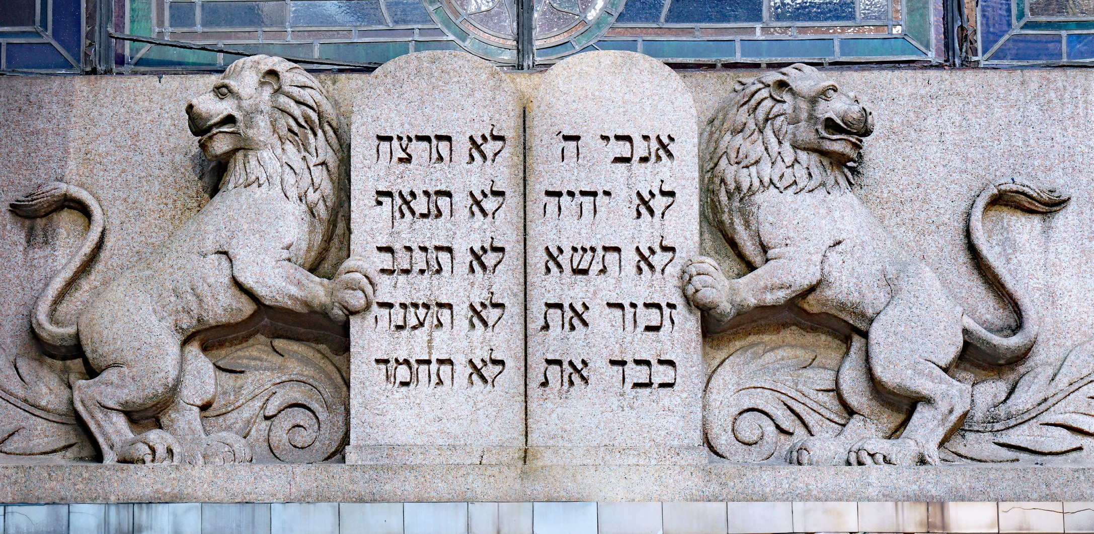 stone relief carving of the ten commandments flanked by two lions