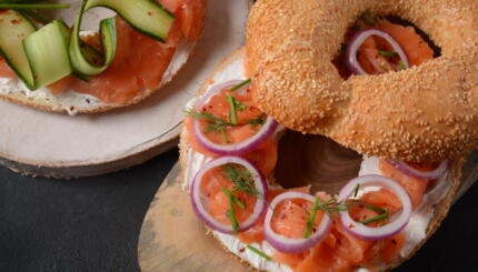 Bagel sandwich with salmon, cream cheese, cucumber, and onions flagel flat bagel