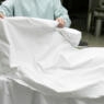 Photo of a doctor removing a sheet from a body