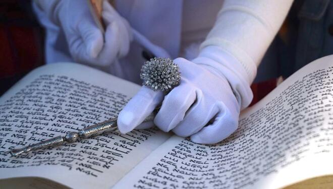 a gloved hand and a hebrew text