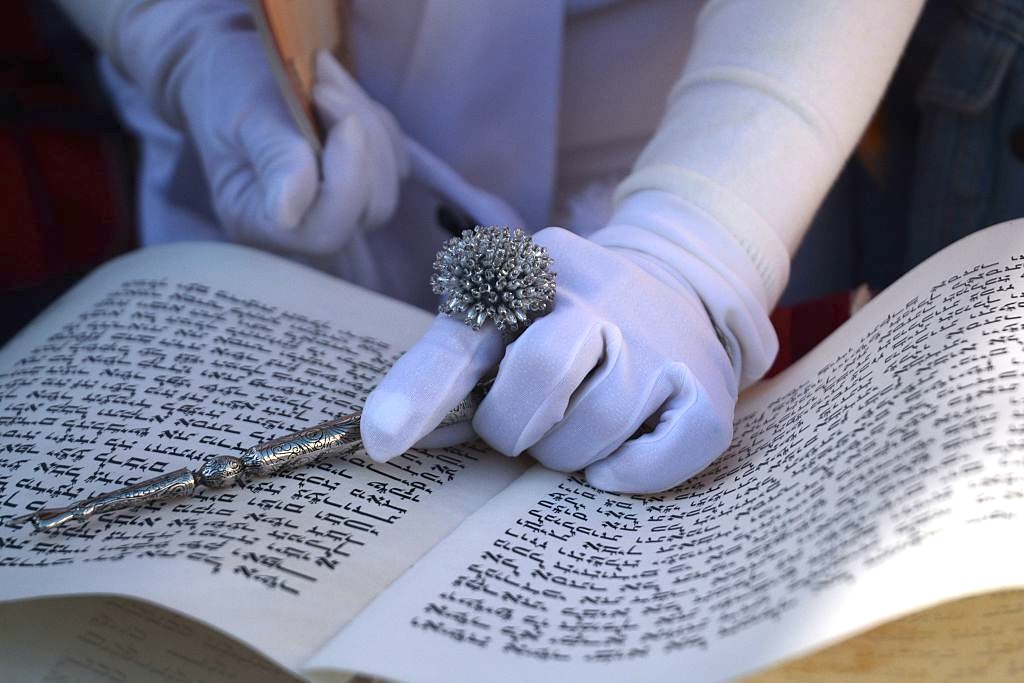 a gloved hand and a hebrew text